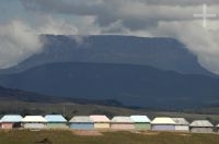 Cabanas imitando habitações indígenas. Ao fundo um tepui. Gran Sabana, sul da Venezuela.